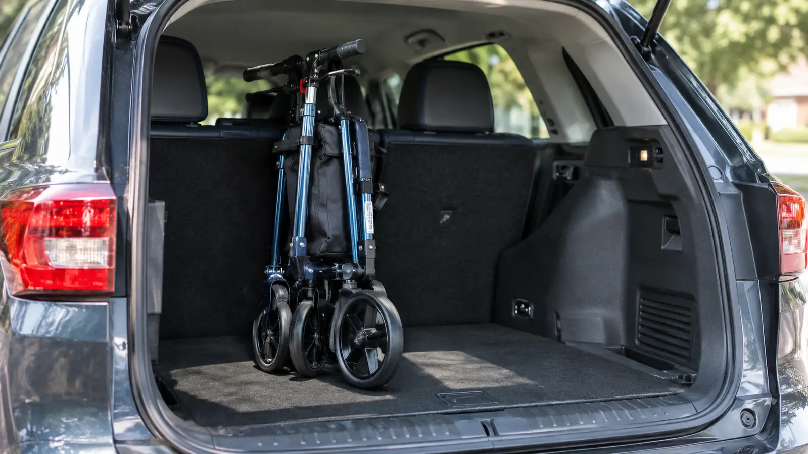 A rollator walker folded and standing in the trunk of a car